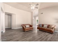 Spacious living room featuring modern flooring, neutral walls and comfortable leather seating at 14624 N 90Th Ln, Peoria, AZ 85381