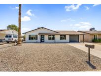 Charming home with a desert landscape front yard and ample parking provided by the long driveway and attached garage at 14635 N 37Th Pl, Phoenix, AZ 85032