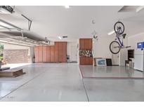 Clean and organized garage area featuring epoxy floors and built-in storage cabinets at 21912 E Desert Hills Dr, Queen Creek, AZ 85142