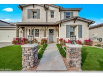 Charming two-story home with a well-manicured lawn and inviting front porch and stone pillar detail at 22870 E Sonoqui Blvd, Queen Creek, AZ 85142