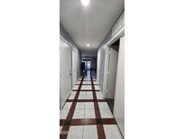 Long hallway with unique tile flooring and neutral paint, connecting the different areas of the home at 23630 W Chambers St, Buckeye, AZ 85326