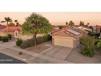 Charming home exterior with solar panels, desert landscaping, and a two-car garage at sunset at 2401 E Antigua Dr, Casa Grande, AZ 85194