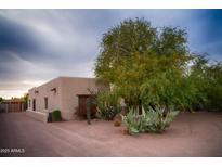Charming southwestern home featuring desert landscaping, a mature tree, and a neutral color palette at 2430 N 56Th St, Phoenix, AZ 85008