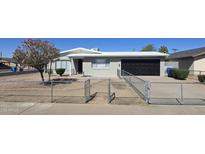 Charming single-story home featuring a xeriscaped yard, gray paint, and a black garage door at 2544 N 52Nd Ave, Phoenix, AZ 85035