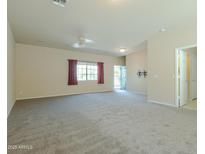 Spacious living room featuring neutral carpet, ceiling fan, and a view of the entry and hallway at 2826 E Tracy Ln # 3, Phoenix, AZ 85032