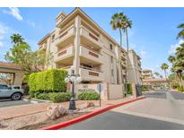 Beautiful multi-story condo with manicured landscaping, palm trees, and an attractive entryway at 4200 N Miller Rd # 325, Scottsdale, AZ 85251