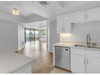 Bright kitchen area with wood floors, quartz countertops, stainless steel appliances, and balcony access at 4200 N Miller Rd # 325, Scottsdale, AZ 85251