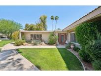 Charming single-story home with lush green lawn, mature trees, and a walkway leading to the front door at 4800 N 68Th St # 357, Scottsdale, AZ 85251