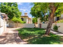 Well-maintained front yard featuring lush lawn and mature trees providing shade at 4818 E Hazel Dr # 1, Phoenix, AZ 85044