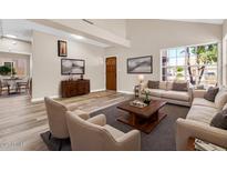 Bright living room featuring wood floors, neutral paint, and large windows at 6837 S Roosevelt St, Tempe, AZ 85283