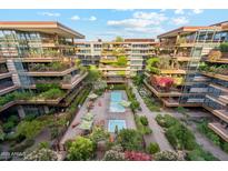 Stunning aerial view of luxurious condos with beautiful landscaping and a sparkling pool at 7121 E Rancho Vista Dr # 6001, Scottsdale, AZ 85251