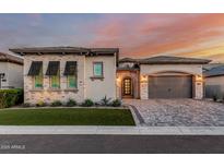 Charming single-Gathering home boasts a paver driveway, two-car garage, and manicured front yard with beautiful desert plants at 8127 E June St, Mesa, AZ 85207
