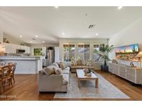 Spacious living area featuring a hardwood floor, recessed lights, and open to the kitchen area at 10239 E Salt Bush Dr, Scottsdale, AZ 85255