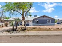 Charming single-story home with gray painted brick, landscaped yard, and mature trees at 1027 S Lola Ln, Tempe, AZ 85281