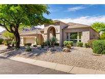 Charming desert home with a light tan exterior, rock landscaping, mature trees, and a two-car garage at 11662 E Parkview Ln, Scottsdale, AZ 85255