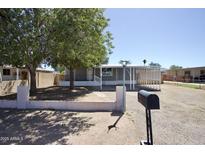 Charming single-story home features a covered parking, lush trees, and gravel landscaping at 319 S 90 Pl, Mesa, AZ 85208