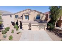 Two-story home featuring a three-car garage, desert landscaping, and a neutral color palette at 42796 W Wild Horse Trl, Maricopa, AZ 85138