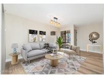 Bright living room featuring a modern couch, stylish decor, and a large window to let in natural light at 5221 N 24Th St # 103, Phoenix, AZ 85016