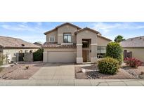 Two-story home featuring a neutral color palette, desert landscaping, a two-car garage and a tile roof at 5423 W Michigan Ave, Glendale, AZ 85308