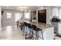 Open-concept kitchen featuring a granite countertop island and sleek stainless steel appliances at 546 S Ellsworth Rd, Mesa, AZ 85208