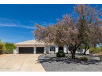 Inviting home exterior featuring a tile roof, black garage doors, desert landscaping, and a circular driveway at 8156 E Questa Rd, Scottsdale, AZ 85255