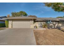 Charming single-story home with a two-car garage, beautiful plants, and inviting gated entrance at 17668 N Del Webb Blvd, Sun City, AZ 85373