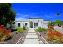 Charming white home with well-manicured desert landscaping and a stone walkway leading to the front door at 1806 W Rosewood Ct, Chandler, AZ 85224