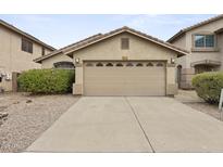 Home featuring a two-car garage with decorative windows and a well-maintained desert landscape at 2152 E Casitas Del Rio Dr, Phoenix, AZ 85024