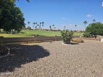 A well-manicured backyard with a golf course in the background and flower bed in the foreground at 2528 N Lema Dr, Mesa, AZ 85215