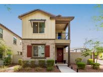 Charming two-story home featuring mixed brick and siding, a small balcony, and a well-maintained front yard at 2540 N Stone Hill Rd, Buckeye, AZ 85396