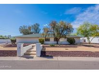 Charming single-story home with well-maintained landscaping and a classic brick facade under a blue sky at 5539 E Dahlia Dr, Scottsdale, AZ 85254