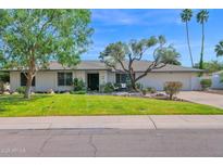 Charming single-story home featuring a well-manicured lawn and mature trees, creating a welcoming curb appeal at 8582 E Via De Dorado --, Scottsdale, AZ 85258