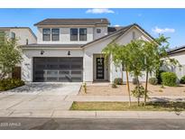 Charming two-story home featuring a modern garage door, low-maintenance landscaping, and a neutral color palette at 10034 E Thunderbolt Ave, Mesa, AZ 85212