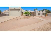 Stylish home with desert landscaping, a two-car garage, and a neutral color palette at 1018 E Knoll St, Mesa, AZ 85203