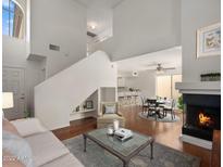 Bright living room boasts an open floorplan, fireplace, staircase, and hardwood flooring at 1095 W Sandy Banks --, Gilbert, AZ 85233