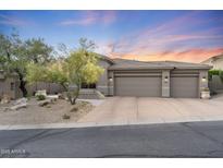 Charming single-story home featuring a three-car garage and xeriscaped front yard at 11462 E Kora Way, Scottsdale, AZ 85255