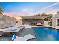 Outdoor pool and spa area featuring lounge seating and a covered patio, perfect for entertaining at 16409 N 65Th Pl, Scottsdale, AZ 85254