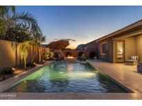 Inviting backyard oasis featuring a sparkling pool, fountain features, and relaxing seating areas perfect for outdoor entertaining at 21283 E Camacho Rd, Queen Creek, AZ 85142