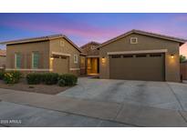 Charming single-Gathering home featuring desert landscaping, multi-car garage, and a welcoming facade under a beautiful twilight sky at 21283 E Camacho Rd, Queen Creek, AZ 85142