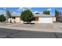 Well-maintained home featuring lovely landscaping, mature tree, and a two-car garage at 235 N 61St Pl, Mesa, AZ 85205