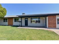 Charming single-story home with a well-maintained front lawn, solar panels, and stylish exterior accents at 3310 W Sweetwater Ave, Phoenix, AZ 85029