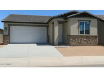 Charming single-story home featuring a two-car garage, stone accents, and neutral stucco exterior at 5633 S 253Rd Ave, Buckeye, AZ 85326