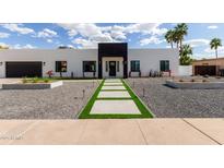 Daytime front exterior view featuring a sleek, modern design with concrete pathway and landscaped yard at 6539 E Sharon Dr, Scottsdale, AZ 85254