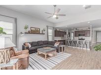 Open-concept living room featuring modern furnishings and an adjacent kitchen with stainless steel appliances at 681 W Belmont Red Trl, San Tan Valley, AZ 85143