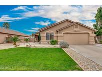Charming single-story home features a lush green lawn and low-maintenance desert landscaping at 7457 W Crystal Rd, Glendale, AZ 85308