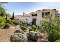 Beautiful white home with desert landscaping, a clay tile roof, and a decorative iron door at 7838 N 54Th Pl, Paradise Valley, AZ 85253