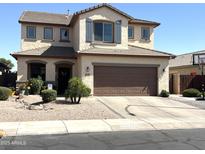 Inviting two-story home featuring a two-car garage, neutral stucco, desert landscaping, and shuttered windows at 11121 E Sombra Ave, Mesa, AZ 85212