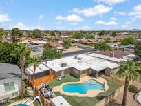 Aerial view showcases a backyard oasis with a pool, palm trees, and privacy fencing in a residential neighborhood at 1308 S Spur --, Mesa, AZ 85204