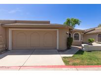 Home featuring a large two-car garage and desert landscaping, perfect for easy maintenance at 18002 N 12Th St # 45, Phoenix, AZ 85022