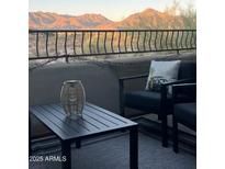 Mountain view balcony with cozy outdoor seating and a decorative lantern on a black table at 19550 N Grayhawk Dr # 2023, Scottsdale, AZ 85255